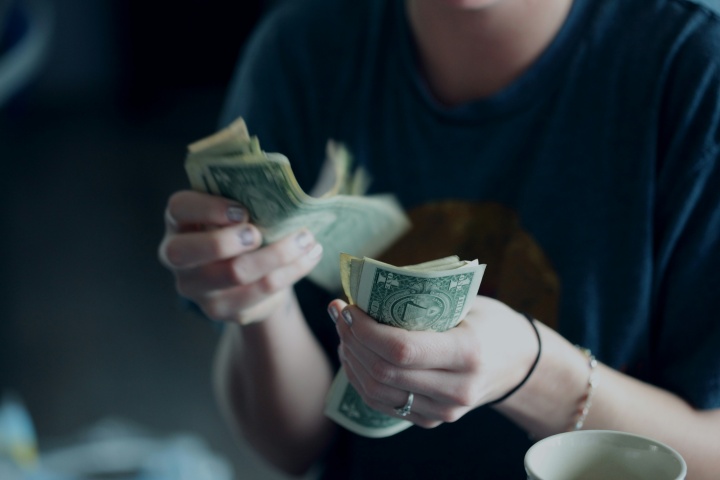 It is not wrong to possess wealth or to acquire things which can enhance life, but the problem comes in how we think about “things” and obsess over wealth in place of putting God first. A man holding a handful of cash.