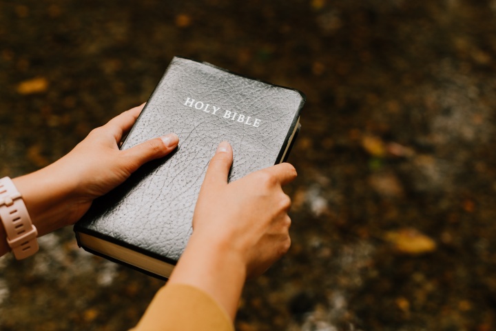 Scripture is where we must go to for absolute truth—to the very inspired words of God. A person holding a Bible.