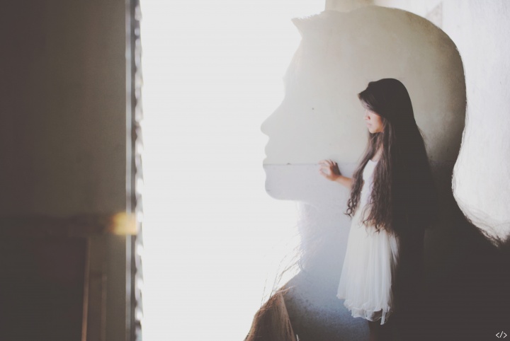 I never felt totally alone because I knew there was God. The silhouette of a young woman.