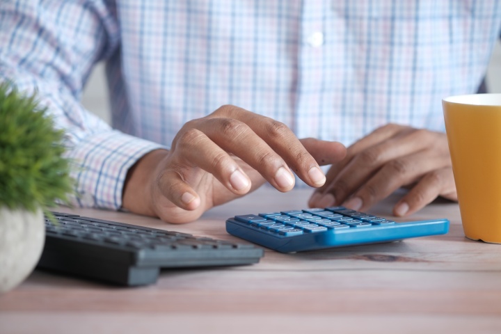 Donating appreciated stock or mutual funds lets you save on your taxes. a man using a calculator